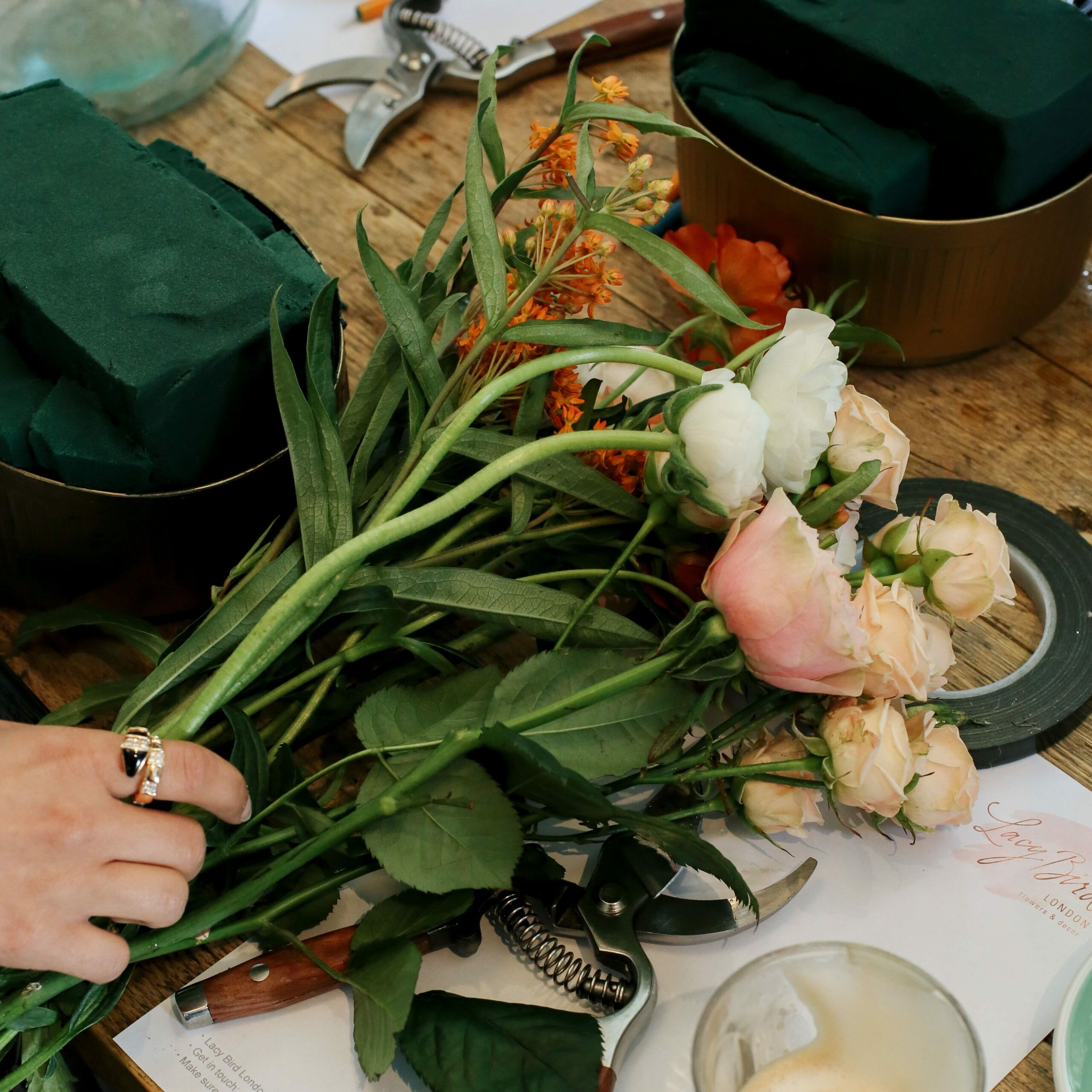 zoom mains de fleuriste qui préparent un bouquet